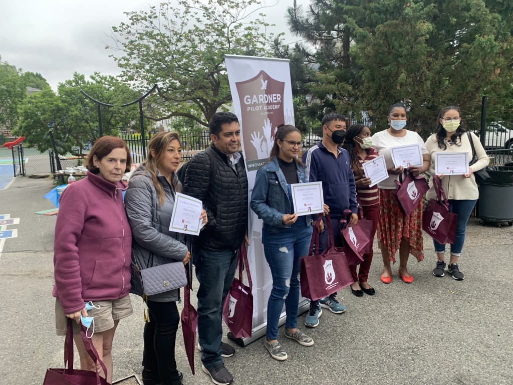 The beginner students are pictured with their teacher and volunteers at the end of the year celebration.